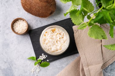 Hindistan cevizi sütlü pirinç lapası ve hafif arka planda kavanozda mango dilimleri. Lezzetli ve sağlıklı kahvaltı kavramı. Beslenme ve enerji gıdaları. Üst görünüm.