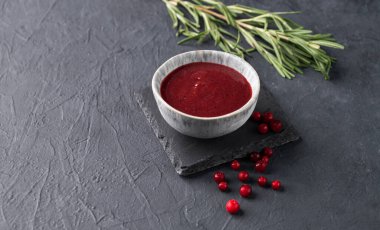 Koyu arkaplanda taze böğürtlen ve biberiyeli bir kasede el yapımı reçel. Ev yapımı sağlıklı yemekleri hesaba katın. Metin için boş alan.