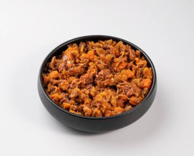 Siyah bir tabakta, beyaz izole edilmiş arka planda sebzeli öküz kuyrukları. Et güveci. Geleneksel İspanyol mutfağı kavramı. Üst görünüm ve kopyalama alanı.