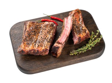 Izgara sığır kaburgası, kırmızı biberli ve ahşap bir tahtada taze otlu beyaz izole edilmiş arka plan. Metin için boş alan.