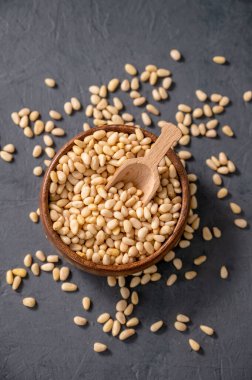 Kasede çam fıstığı ve karanlık bir arka planda dağınık bir çam fıstığı. Doğal, organik ve sağlıklı yiyecek ve atıştırmalık kavramı..