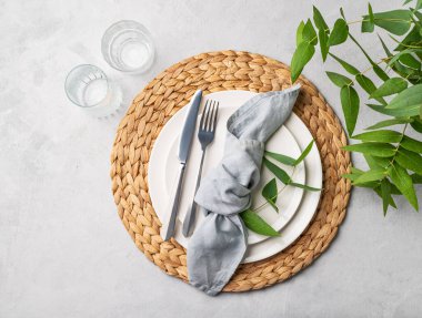 Bahar kutlaması, düğün, doğum günü ya da arka planda okaliptüs dalları olan anneler günü için beyaz tabak ve gözlüklü şenlik masası. Restoran menüsü konsepti. Üst görünüm 