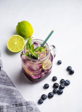 Yabanmersinli mojito ya da limonlu, buzlu ve naneli limonata. Arka planda böğürtlen ve meyveli. Yaz tazeleyici içecek konsepti. 