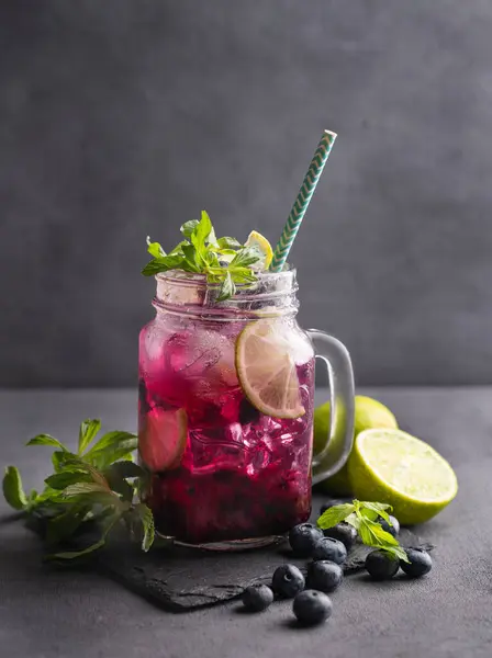 Böğürtlenli mojito ya da limonata, nane ve buzlu koyu bir arka planda. Meyve ve meyvelerden yapılan sağlıklı alkolsüz içecek. Metin için ön görünüm ve boş alan.