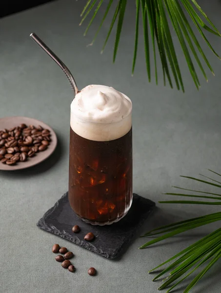 Ledová Káva Pěnou Sklenici Černém Prkně Tmavozeleném Pozadí Kávovými Zrny — Stock fotografie