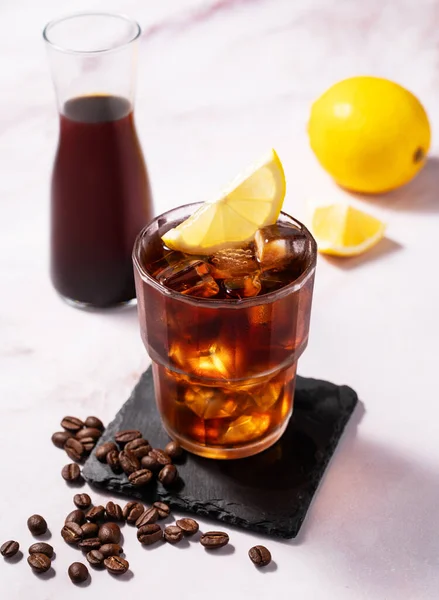병이있는 대리석 배경에 얼음과 레몬이있는 유리에서 차가운 커피를 신선한 — 스톡 사진