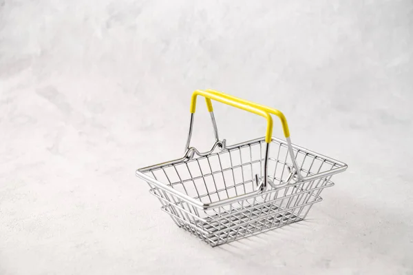 Empty shopping basket  from a supermarket on a gray isolated background. Free space for text.