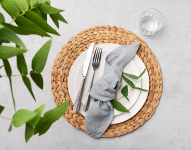 Bahar kutlaması, düğün, doğum günü ya da arka planda okaliptüs dalları olan anneler günü için beyaz tabaklar ve cam kaplı şenlik masası. Üst görünüm ve kopyalama alanı.