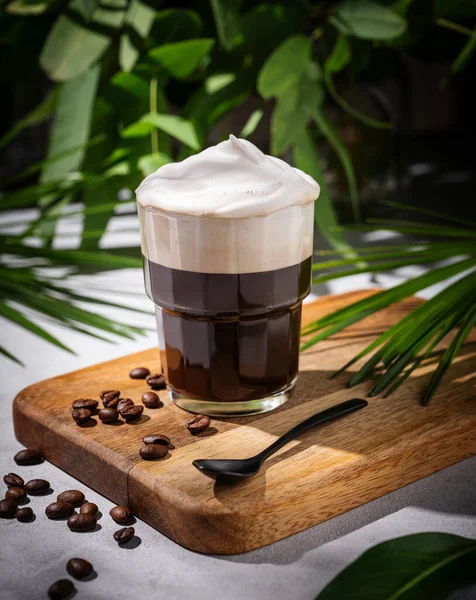 Ledová Káva Sklenici Pěnou Dřevěné Desce Světlém Pozadí Kávovými Zrny — Stock fotografie