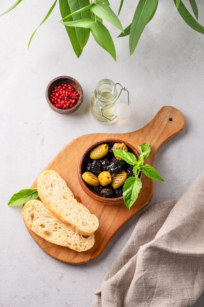 Taze chiabatta dilimleri ve zeytinyağı ve fesleğenli yeşil ve siyah zeytinler. Vejetaryen sağlıklı atıştırmalıklar konsepti. Üst görünüm. 