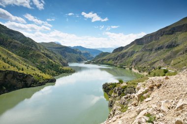 Dağlı güzel bir manzara ve bulutlu güneşli bir yaz gününde bir nehir. Dağıstan.