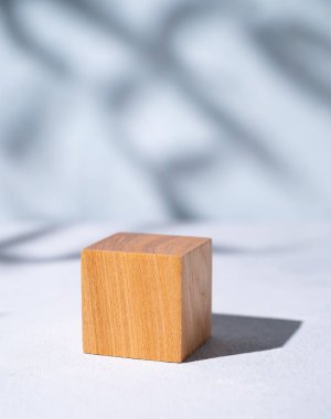 Ürün tanıtımı için tahta küp boş ya da mavi arka planda gölgeli maket. Moda nötr estetik güzellik ve kozmetik sahnesi. Metin için boş alan.