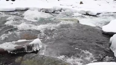 Kışın Arkhyz 'de kar ve buzla kaplı dağ nehri, bulutlu bir kış gününde. Kafkas Dağları, Rusya. 