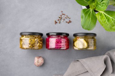 Kavanozda turşulu biber, kırmızı soğan ve salatalık taze otlar ve baharatlarla mavi arka planda. Geleneksel ev yapımı konserve atıştırmalıklar. Sağlıklı mayalanmış yiyecek. Üst görünüm ve kopyalama alanı. 