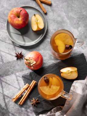 Taze elmalı ev yapımı elma pançı, tarçın ve taze meyveli koyu arkaplanda baharatlar. Sıcak, sağlıklı bir sonbahar ya da kış içkisi. Sade ve rahat atmosfer kavramı. Üst görünüm.