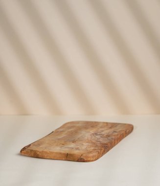 Bej arkaplanda gölgeler olan soyut boş tahta tahta. Promosyon ürün sunumu, satış ya da kozmetik ekran düzeni konsepti. Ön görünüm ve boşluk kopyala.