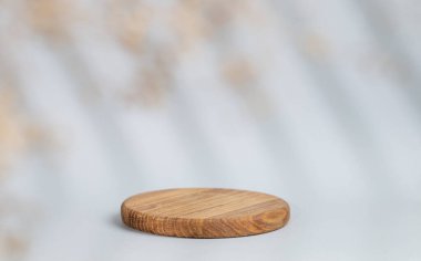 Gri arka planda gölgeler olan soyut boş tahta. Promosyon ürün sunumu, satış ya da kozmetik ekran düzeni konsepti. Ön görünüm ve boşluk kopyala.