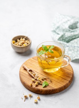 Papatya çayı ve nane arkaplanda kuru çiçekli cam bardak. Sağlık ve uyku için sağlıklı bir detoks içeceği konsepti. Metin için boş alan.