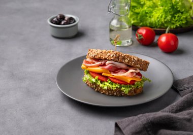 Pastırmalı, peynirli, domatesli ve zeytinli, marullu sandviç. Kahvaltıda ya da öğle yemeğinde sağlıklı atıştırmalık konsepti. Boşluğu kopyala