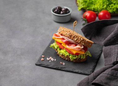 Pastırmalı, peynirli, domatesli ve zeytinli, marullu sandviç. Kahvaltıda ya da öğle yemeğinde sağlıklı atıştırmalık konsepti. Boşluğu kopyala.