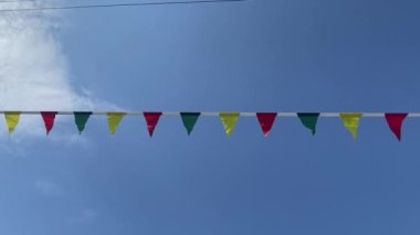 Çok renkli çelenkler ya da rüzgarda dalgalanan bayrak, güneşli bir yaz gününde mavi gökyüzü ile dağda. Sokak festivallerinin festival tasarımı konsepti. Yoga festivaline geri çekilin..