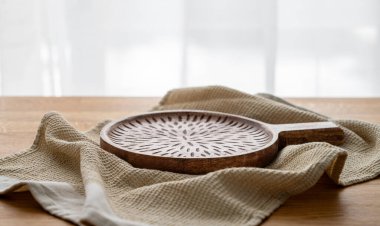 Pencerenin önünde mutfak havlusuyla ahşap masa üstü boş kesim tahtası. Yemek servisi yapmak ya da ev yapımı ve sağlıklı yemek hazırlamak için. Ön görünüm ve boşluk kopyala.