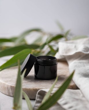 Beyaz arka planda gölgeli ve yeşil yapraklı boş mermer levha ya da tepsi. Promosyon ürünlerinin sunumu, satışı veya kozmetik kopyalama alanının tanıtımı için tasarım kavramı.