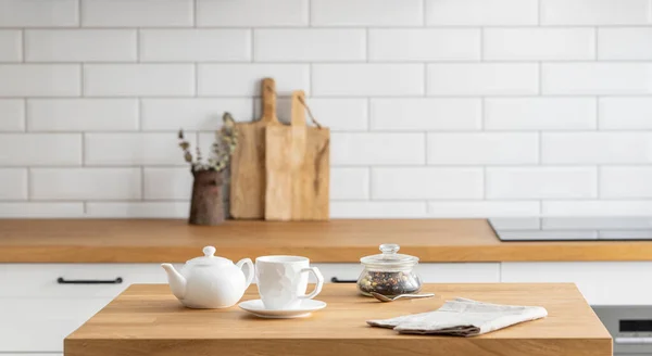 木制橡木桌子 一杯茶和一个水壶在厨房前面 白色砖背景 斯堪的纳维亚风格的舒适早餐概念 — 图库照片