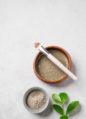 Yapraklı, hafif arka planda fırçalı mavi kil. Ev yapımı cilt bakımı organik kozmetik ürünleri. Üst görünüm ve kopyalama alanı.