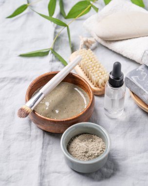 Mavi kil, sabun, fırça, havlu ve hafif keten kaplamalı organik kozmetik. Ev yapımı cilt bakım ürünleri hazırlama kavramı. 