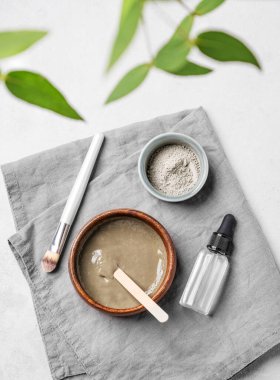 Mavi kil, serum, fırça ve dallı organik kozmetik düz bir zemin. Ev yapımı cilt bakım ürünleri hazırlama konsepti. Üst görünüm.