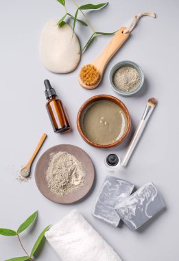 Mavi killi organik kozmetik, serum, sabun, fırça ve havluyla gölgeli bir arka plan. Ev yapımı cilt bakım ürünleri hazırlama konsepti. Üst görünüm.