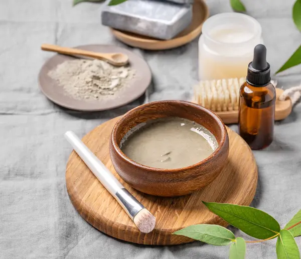 Mavi kil, sabun, fırça, serum ve mum kaplı organik kozmetik. Ev yapımı cilt bakım ürünleri hazırlama kavramı. 