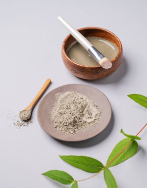 Hafif arka planda, dallı bir kasede mavi kil. Ev yapımı cilt bakımı organik kozmetik ürünleri ve spa tedavisi. 