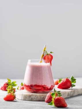 Bir bardak çilekli milkshake ya da mermer bir tahtada taze böğürtlenli çilekli smoothie. Sağlıklı yiyecek ve içecek konsepti. Boşluğu kopyala.