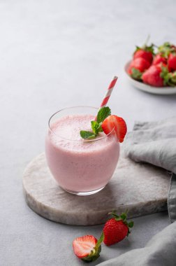 Bir bardak taze çilekli smoothie. İçinde taze böğürtlen ve peçeteyle mermer bir tahta üzerinde naneli. Yaz organik milkshake konsepti. Boşluğu kopyala.