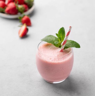 Hafif arkaplanlı taze çilekli bir bardak taze meyve püresi. Yaz organik milkshake konsepti. Boşluğu kopyala.