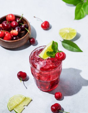 Naneli, limonlu ve buzlu vişneli mojito kokteyli. Arka planda taze böğürtlen ve gölge var. Yaz modası içeceği konsepti. Üst görünüm.
