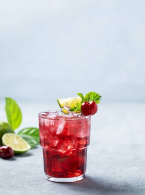 Mavi arka planda naneli, limonlu ve buzlu vişneli mojito kokteyli. Yaz modası içeceği konsepti. Boşluğu kopyala.