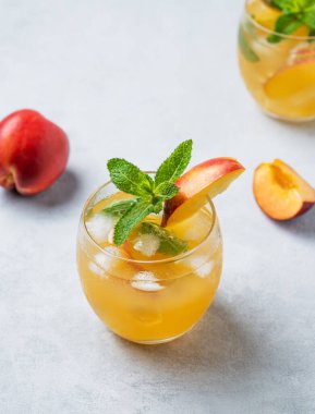 Şeftali kokteyli, limonata ya da arka planda buzlu çay. Buzlu, naneli ve taze meyveli soğuk alkolik ya da alkolsüz yaz içeceği kavramı. Üst görünüm.