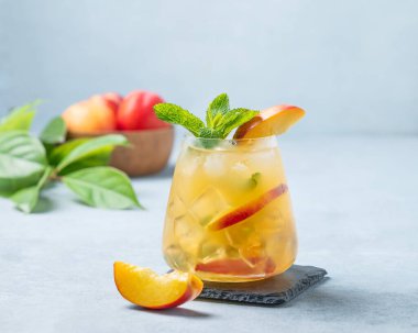 Şeftali kokteyli, limonata ya da arka planda buzlu çay. Soğuk alkolik ya da alkolsüz, buzlu, naneli ve taze meyveli yaz içeceği kavramı. 