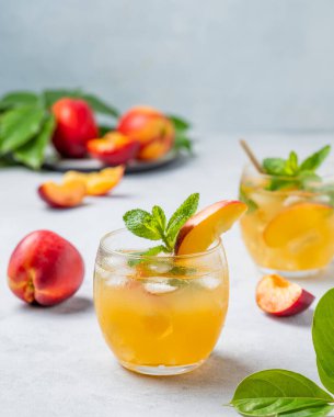 Şeftali kokteyli, limonata ya da arka planda buzlu çay. Buzlu, naneli ve taze meyveli soğuk alkolsüz yaz içeceği kavramı. 