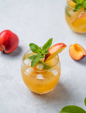 Şeftali kokteyli, limonata ya da arka planda buzlu çay. Buzlu, naneli ve taze meyveli soğuk alkolsüz yaz içeceği kavramı. Üst görünüm. 