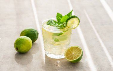 Naneli ve buzlu bir bardakta limonata. Mojito kokteylini limonlu arka planda ve sabah ışığını gölgeli bir şekilde tazeliyorum. Yaz soğuk içecekler konsepti. Boşluğu kopyala.