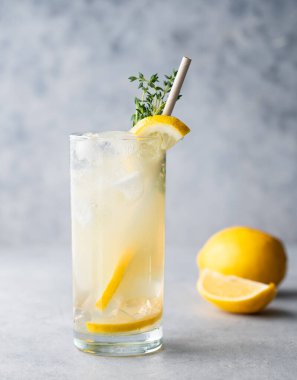 Limonlu, naneli ve buzlu mojito. Mavi arka planda limonata ve meyveler kapanıyor. Yaz modasına uygun soğuk içecek konsepti. Ön görünüm.