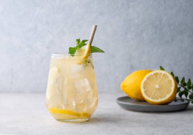 Taze limonlu, naneli ve buzlu mojito kokteyli. Hafif bir arka planda meyveli limonata içmek. Yaz modasına uygun soğuk içecek konsepti. Ön görünüm.