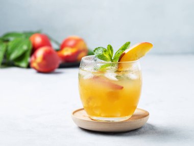 Şeftali kokteyli, limonata ya da açık mavi arka planda buzlu çay. Buzlu, naneli ve taze meyveli soğuk alkolsüz yaz içeceği kavramı. Boşluğu kopyala.