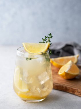 Taze limonlu, naneli ve buzlu mojito kokteyli. Hafif arka planda ahşap tahta ve peçeteyle narenciye içeceği tazeliyorum. Yaz modasına uygun soğuk içecek konsepti. Ön görünüm.