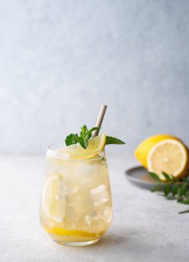 Taze limonlu, naneli ve buzlu mojito kokteyli. Hafif bir arka planda limonata içeceğiz. Yaz modasına uygun soğuk içecek konsepti. Ön görünüm ve boşluk kopyala.