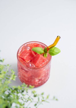 Bir bardak taze karpuz kokteyli, fesleğenli ve buzlu taze otlu. Sağlıklı yaz içeceği ya da kafe ya da bar menüsü için limonata. Üst görünüm ve kopyalama alanı.